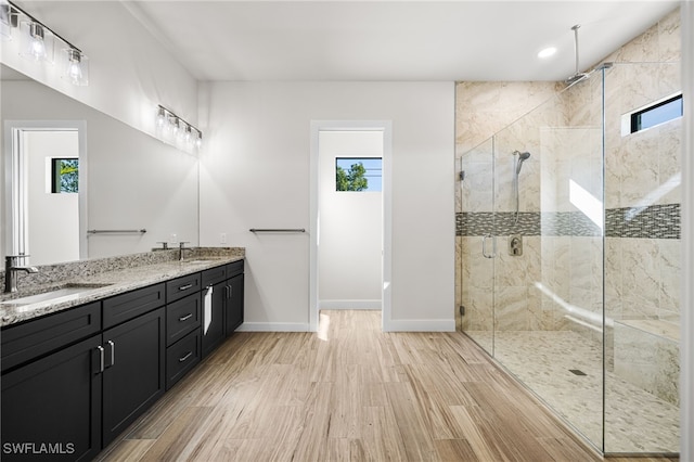 bathroom featuring a shower with shower door, wood-type flooring, and vanity