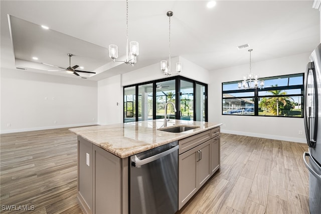 kitchen with gray cabinets, sink, a kitchen island with sink, appliances with stainless steel finishes, and light stone counters