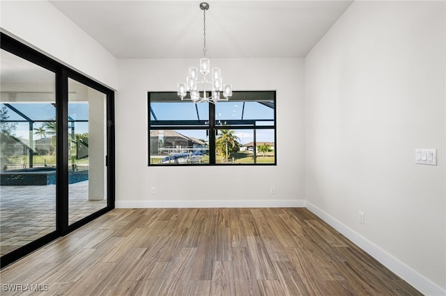 unfurnished room featuring hardwood / wood-style flooring and a chandelier