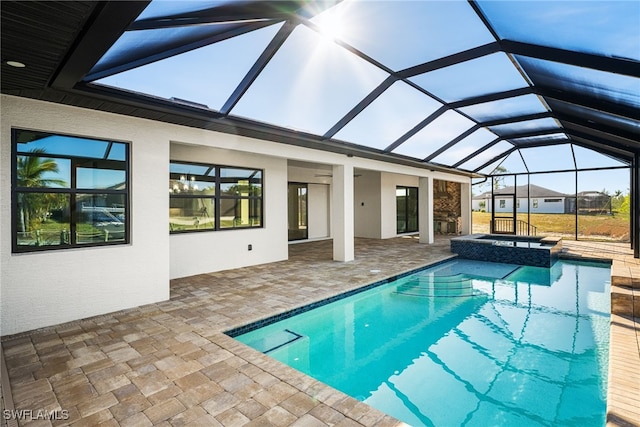 view of swimming pool with a patio, glass enclosure, and an in ground hot tub