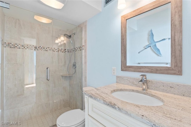 bathroom featuring a stall shower, visible vents, vanity, and toilet