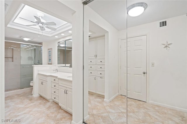 bathroom with a tray ceiling, a closet, visible vents, and a sink