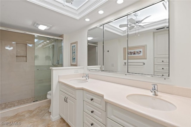 full bath featuring a stall shower, a sink, toilet, and crown molding