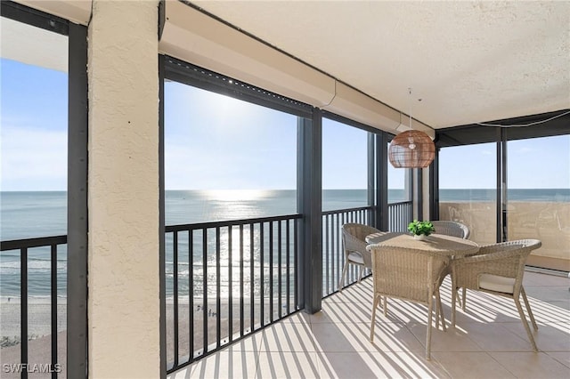 sunroom / solarium featuring a water view and a wealth of natural light