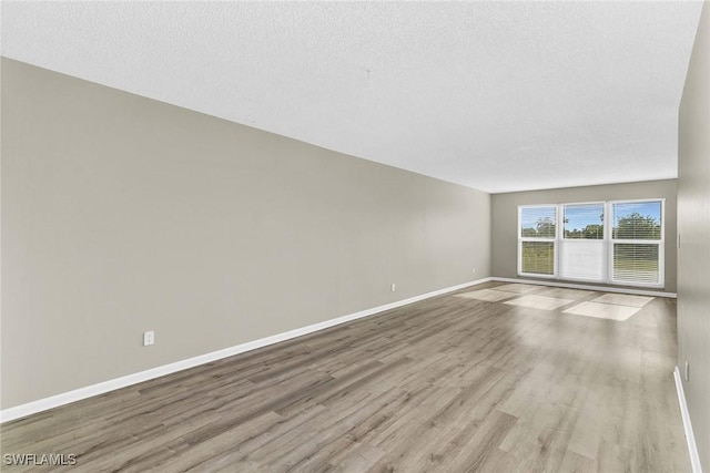 unfurnished room featuring a textured ceiling and light wood-type flooring