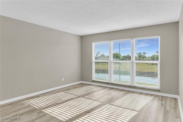 spare room with wood-type flooring and a textured ceiling