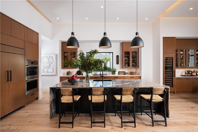 kitchen with a kitchen breakfast bar, decorative light fixtures, dark stone countertops, and a spacious island