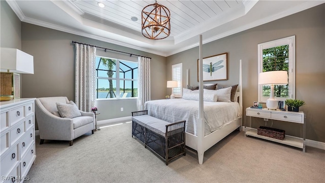 carpeted bedroom featuring a raised ceiling, multiple windows, and a chandelier