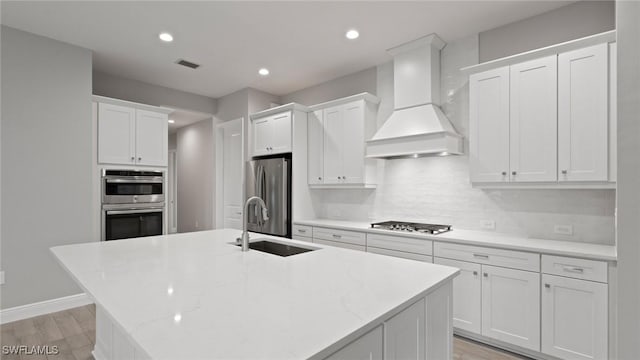4075 Pegasus Way, Naples, FL 34120 - kitchen featuring stainless steel appliances, a sink, custom range hood, backsplash, and white cabinets