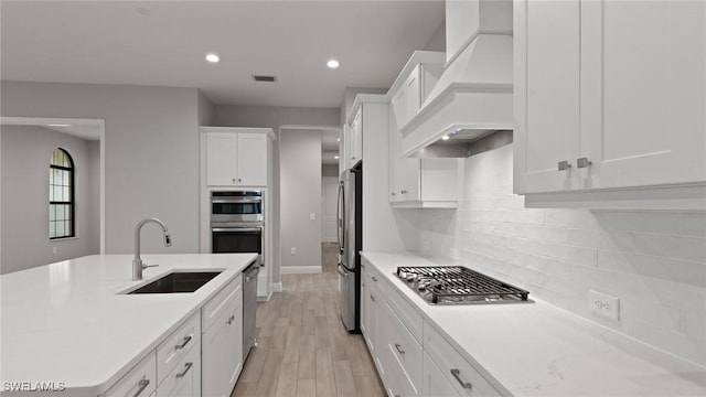 4075 Pegasus Way, Naples, FL 34120 - kitchen with a sink, stainless steel appliances, custom exhaust hood, white cabinetry, and light countertops
