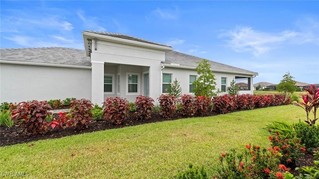 4075 Pegasus Way, Naples, FL 34120 - view of property exterior featuring a yard and stucco siding