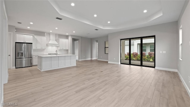 4075 Pegasus Way, Naples, FL 34120 - unfurnished living room with a tray ceiling, light wood finished floors, baseboards, and recessed lighting