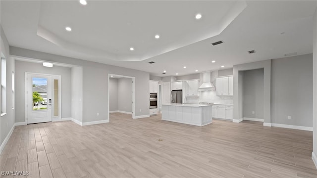 4075 Pegasus Way, Naples, FL 34120 - unfurnished living room featuring light wood-type flooring, a tray ceiling, baseboards, recessed lighting, and a sink