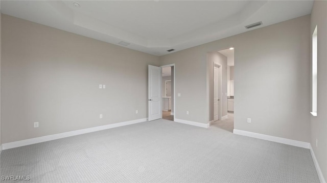 4075 Pegasus Way, Naples, FL 34120 - unfurnished bedroom featuring light colored carpet, a raised ceiling, baseboards, and connected bathroom