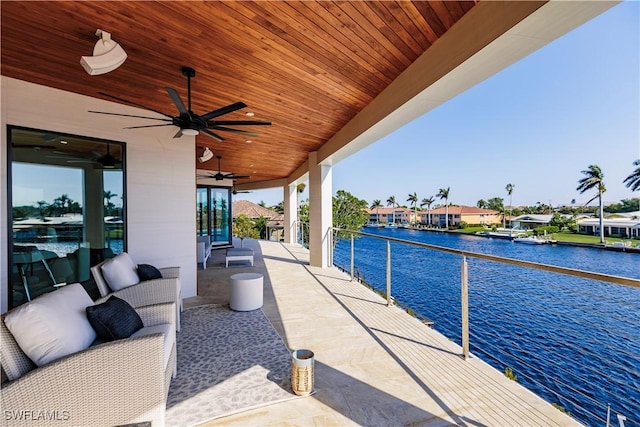 view of patio / terrace with an outdoor hangout area, a balcony, ceiling fan, and a water view