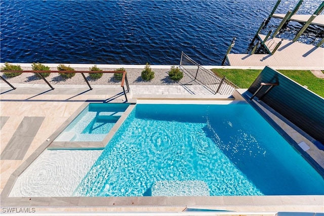 view of pool with an in ground hot tub, a water view, and a patio area