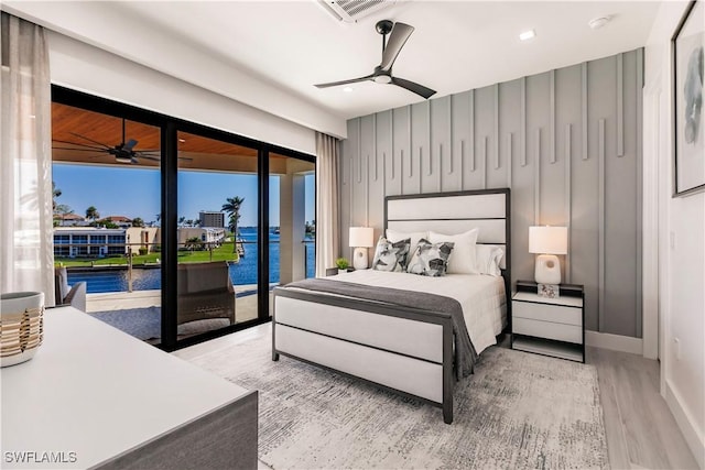 bedroom with ceiling fan, a water view, access to outside, and light wood-type flooring