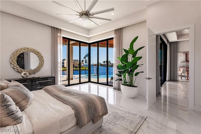 bedroom featuring access to exterior, ceiling fan, and a water view