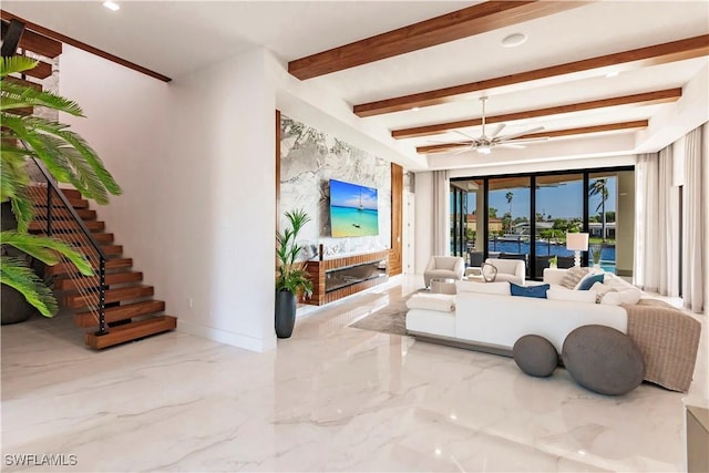 living room featuring ceiling fan, beam ceiling, and a brick fireplace