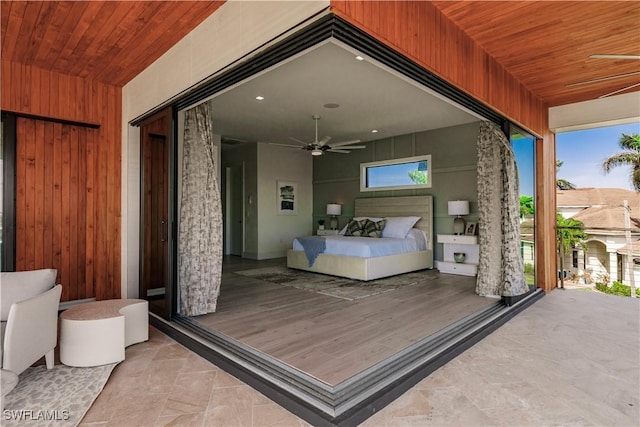 bedroom featuring wooden ceiling and wood walls