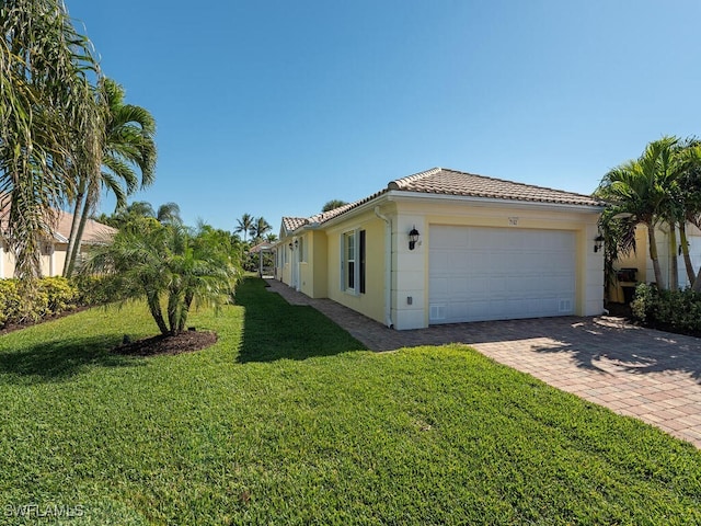 view of home's exterior featuring a garage and a lawn