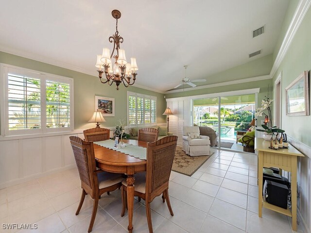 tiled dining room with ceiling fan with notable chandelier, vaulted ceiling, and ornamental molding