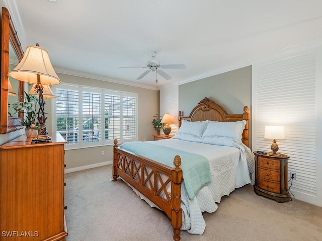 carpeted bedroom featuring ceiling fan and crown molding