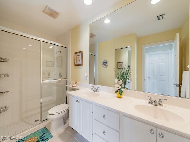 bathroom featuring toilet, vanity, tile patterned floors, and a shower with shower door