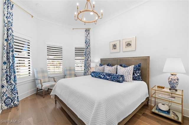 bedroom with an inviting chandelier, ornamental molding, and hardwood / wood-style flooring