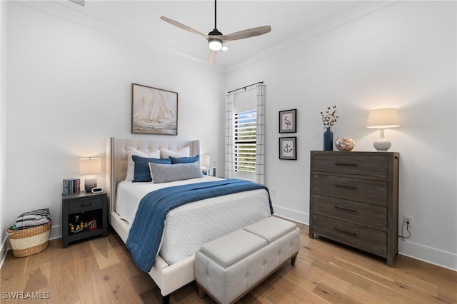 bedroom featuring ceiling fan, light hardwood / wood-style floors, and crown molding