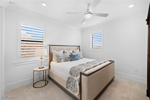 carpeted bedroom featuring ceiling fan and crown molding