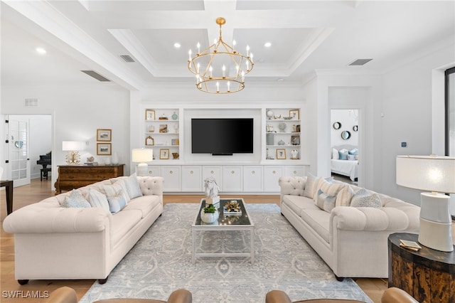 living room with built in shelves, an inviting chandelier, light wood-type flooring, crown molding, and coffered ceiling