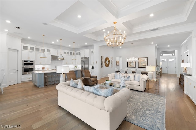 living room with hardwood / wood-style flooring, a notable chandelier, beamed ceiling, and ornamental molding