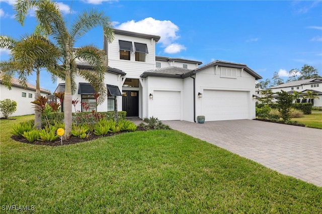 view of front of home with a front yard and a garage