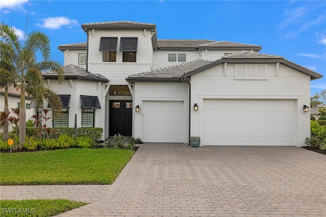 view of front of property featuring a front yard and a garage