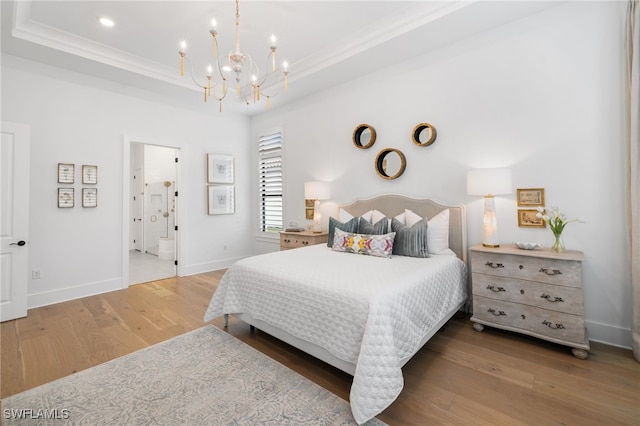 bedroom with crown molding, an inviting chandelier, a raised ceiling, and wood-type flooring