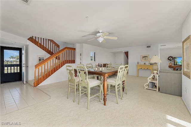 dining area featuring ceiling fan and light colored carpet