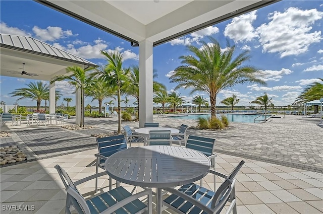 view of patio with a community pool and ceiling fan