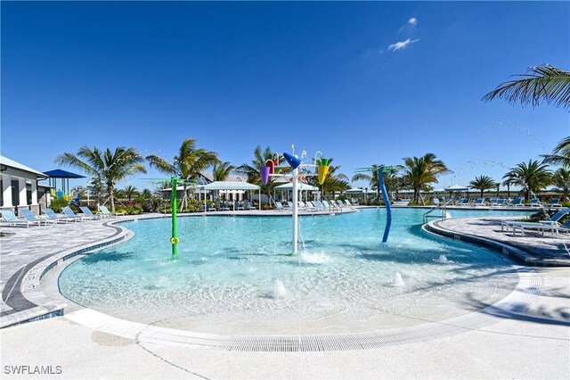 view of swimming pool with pool water feature and a patio