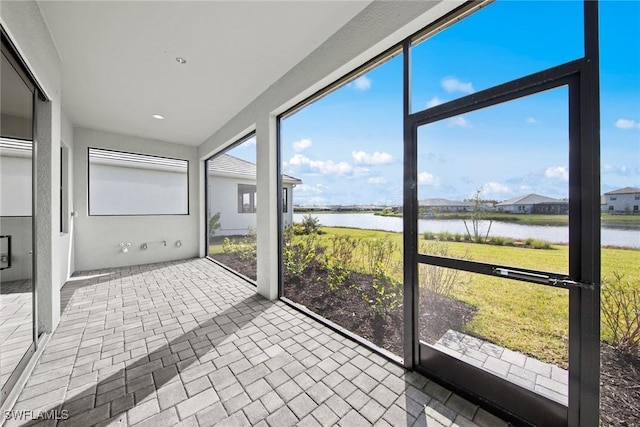 unfurnished sunroom with a water view and plenty of natural light