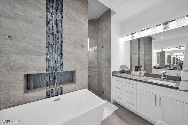 bathroom featuring vanity, tile walls, and independent shower and bath