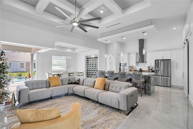 living room with beam ceiling, ceiling fan, coffered ceiling, and a high ceiling