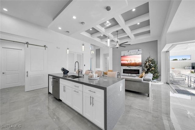 kitchen with coffered ceiling, sink, an island with sink, beamed ceiling, and white cabinetry