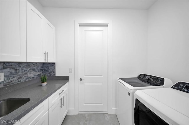 washroom featuring cabinets, separate washer and dryer, and sink