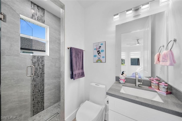 bathroom with vanity, toilet, an enclosed shower, and ceiling fan