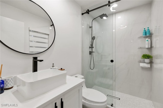 bathroom featuring a shower with shower door, toilet, and vanity