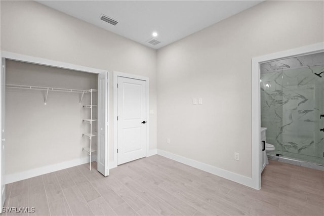 1201 E 7th St, Lehigh Acres, FL 33972 - unfurnished bedroom featuring light wood-style floors, baseboards, a closet, and ensuite bathroom