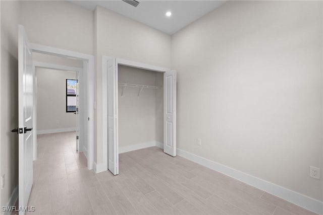 1201 E 7th St, Lehigh Acres, FL 33972 - unfurnished bedroom with baseboards, light wood-style floors, a closet, and recessed lighting