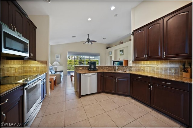 kitchen with decorative backsplash, kitchen peninsula, appliances with stainless steel finishes, and vaulted ceiling