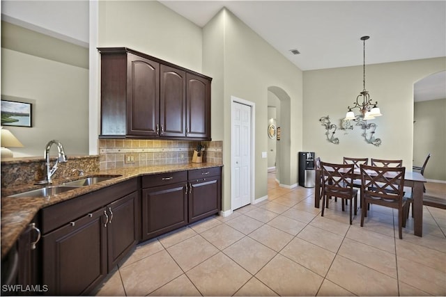 kitchen featuring sink, hanging light fixtures, a chandelier, decorative backsplash, and dark brown cabinets